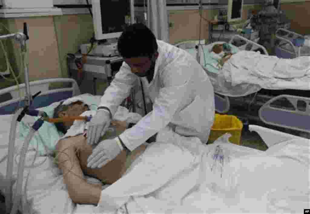 A Libyan doctor treats a wounded man who was injured last week during the demonstration against country's leader Moammar Gadhafi, in Benghazi, February 24, 20011. (AP Image)