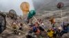 Orang-orang mencoba menangkap sesaji (persembahan) yang dilempar dari puncak Gunung Bromo oleh warga suku Tengger dan wisatawan lokal di Probolinggo, provinsi Jawa Timur, bagian dari festival Hindu &#39;Kasada Yadnya&#39;.