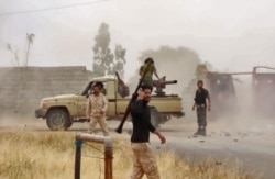 FILE - An image grab from a video reportedly shows fighters of Libyan military strongman Khalifa Haftar's self-proclaimed Libyan National Army on a road south of the capital Tripoli, May 26, 2019.