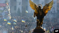 Para aktivis pro-Uni Eropa terlihat berada di sekitar patung "The Archangel Michael" dalam aksi protes di lapangan Kemerdekaan di Kiev, Ukraina (14/12).