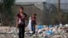 Youths sift through waste at a landfill in Khan Yunis in the southern Gaza Strip on October 15, 2024, amid the ongoing war between Israel and the Palestinian militant group Hamas in the besieged Palestinian territory.