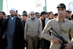 Abu Mahdi al-Muhandis, center, a commander in the Popular Mobilization Forces, attends a funeral procession of Hashd al-Shaabi (paramilitary forces) members, who were killed by U.S. airstrikes in Qaim district, in Baghdad, Iraq, Dec. 31, 2019.