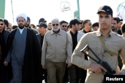 Abu Mahdi al-Muhandis, center, a commander in the Popular Mobilization Forces, attends a funeral procession of Hashd al-Shaabi (paramilitary forces) members, who were killed by U.S. airstrikes in Qaim district, in Baghdad, Iraq, Dec. 31, 2019.