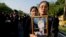Thai mourners, carrying a portrait of late Thai King Bhumibol Adulyadej, gather in front of a replica of the royal crematorium in Bangkok, Thailand, Oct. 26, 2017.