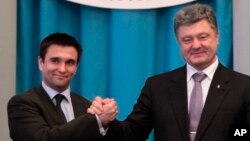 Ukrainian President Petro Poroshenko (R) congratulates new Ukrainian Foreign Minister Pavel Klimkin in Kyiv, June 19, 2014.