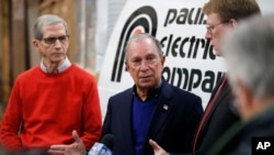 Former New York City Mayor Michael Bloomberg, center, speaks during a news conference after touring the Paulson Electric Co., Dec. 4, 2018, in Cedar Rapids, Iowa. 