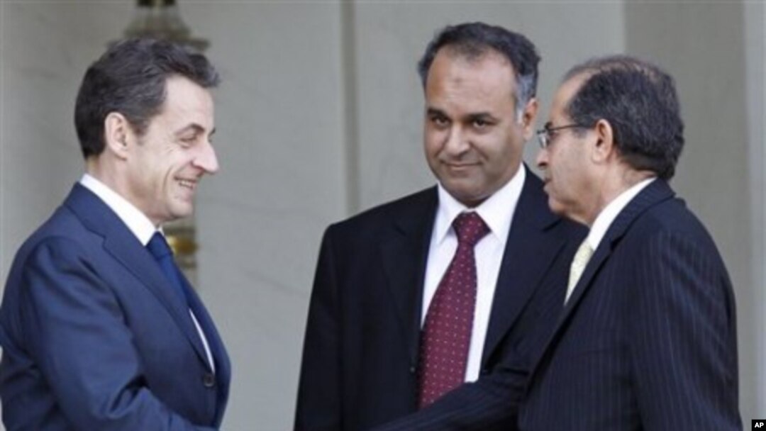 French President Nicolas Sarkozy, left, shakes hands with Mahmoud Jibril, right, and Ali Al-Esawi, representatives of the newly formed council based in the eastern Libyan city of Benghazi, after a meeting at the Elysee Palace, in Paris, March 10, 2011