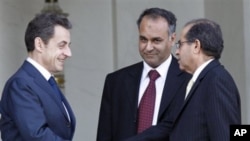 French President Nicolas Sarkozy, left, shakes hands with Mahmoud Jibril, right, and Ali Al-Esawi, representatives of the newly formed council based in the eastern Libyan city of Benghazi, after a meeting at the Elysee Palace, in Paris, March 10, 2011