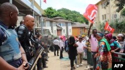 La police anti-émeute monte la garde devant la préfecture alors que les manifestants déploient des banderoles à Mamoudzou dans le territoire français d'outre-mer de Mayotte le 20 février 2018.