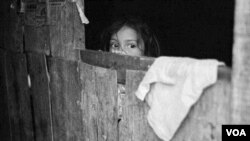 Karen María Hernández de 5 años observa como niños juegan en su barrio a las afueras de Tegucigalpa, Honduras.