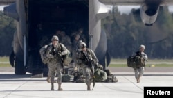 FILE - Soldiers from the U.S. 173 airborne brigade, who are among the troops participating in the exercises in western Ukraine, are seen exiting a C-130 transport plane.