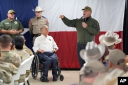 FILE - Kepala Perbatasan AS yang baru, Tom Homan (kanan), berdiri bersama Gubernur Texas Greg Abbott (tengah), memberikan pernyataan di sebuah fasilitas di perbatasan AS-Meksiko, Eagle Pass, Texas, 26 November 2024. (Eric Gay, Arsip/AP)