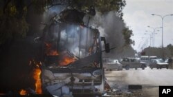 Un autobus en feu sur une route menant à Benghazi.