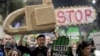 FILE - Protesters carrying a mock chainsaw and signs that read "All for the forests" march in Bucharest, Romania, Nov. 3, 2019. A large grouping of countries have agreed to improve protections for environmental defenders who risk abuse and harm because of their activism.
