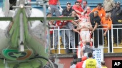 Un aficionado herido es cargado en camilla durante una batalla campal de aficionados del fútbol.