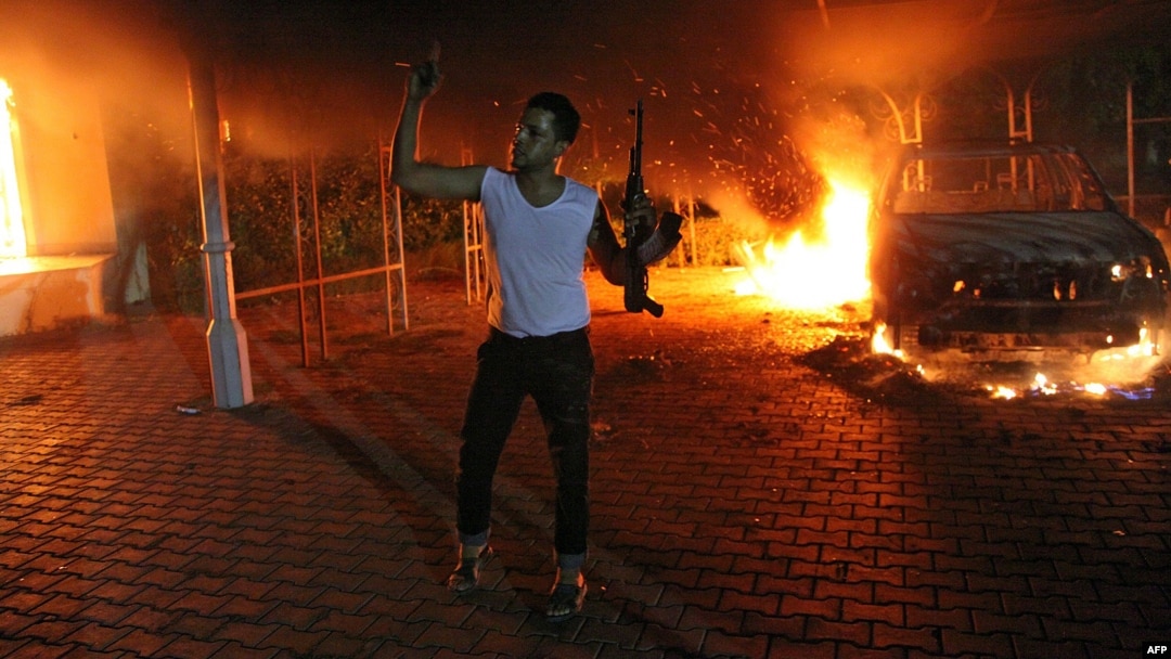 Seorang pria bersenjata berada di komplek konsulat AS di Benghazi, Libya yang terbakar akibat serangan para demonstran yang marah atas film yang dinilai menghina Nabi Muhammad (11/9).