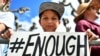 FILE - Zachary Chakin holds a sign as crowds participate in the March for Our Lives rally in support of gun control, March 24, 2018, in San Francisco.