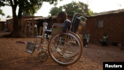 Giovanni Mougounou, 10, who lost both legs in April 2013 to what his family say was a rocket-propelled grenade launched by Seleka fighters on a church, pushes his wheel chair in the Boy Rabe district of Bangui, Central African Republic, February 4, 2014.