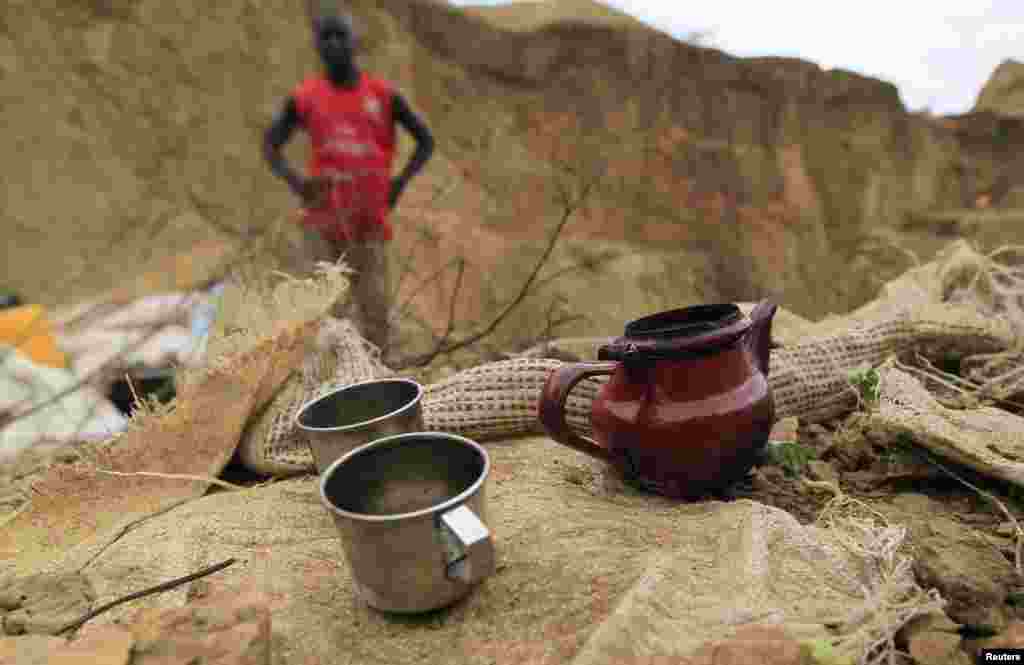 A Teapot and cups used by miners are placed on the ground at a mine in Minna, Niger State June 23, 2013. Picture taken June 23, 2013. REUTERS/Afolabi Sotunde (NIGERIA - Tags: ENERGY BUSINESS EMPLOYMENT SOCIETY) - RTX10YTL