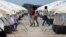 FILE - Venezuelan migrant women walk through a camp run by the U.N. refugee agency UNHCR in Maicao, Colombia, May 7, 2019. 
