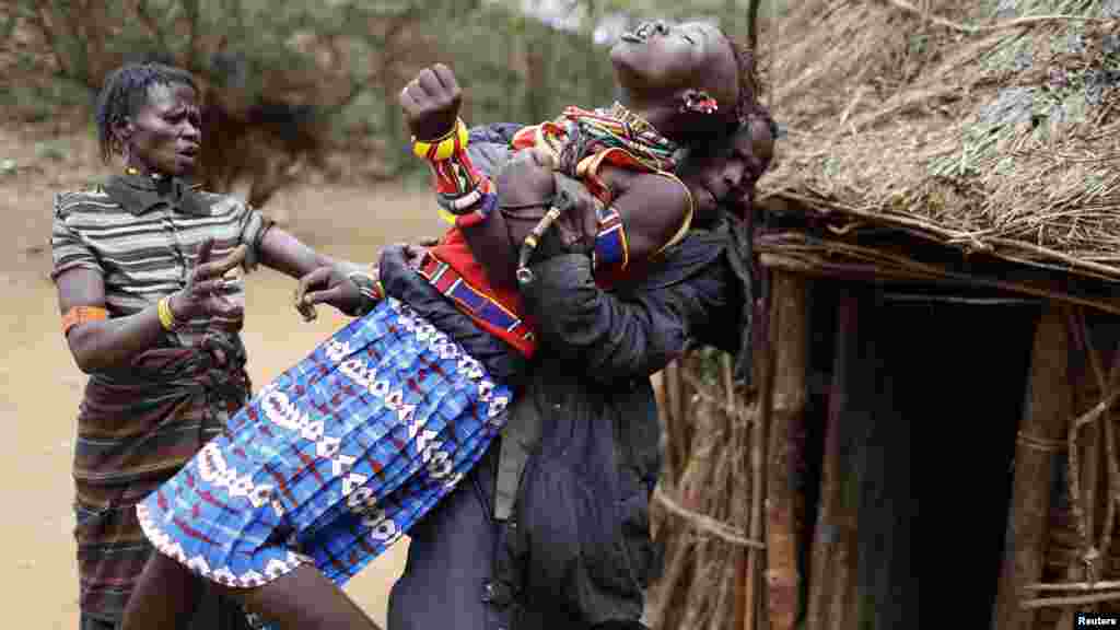 Un homme tient une fille qui tente de s'échapper après avoir appris qu'elle a été mariée&nbsp; de force, à environ 80 km (50 milles) de la ville de Marigat dans le comté de Baringo, 7 décembre 2014.