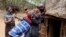 FILE - A man holds a girl as she tries to escape when she realized she is to to be married, about 80 km (50 miles) from the town of Marigat in Baringo County, Dec. 7, 2014.