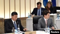 Madaxweynaha Shuunaha Xi Jinping (bidix) iyo Ra'isul Wasaaraha Canada Justin Trudeau