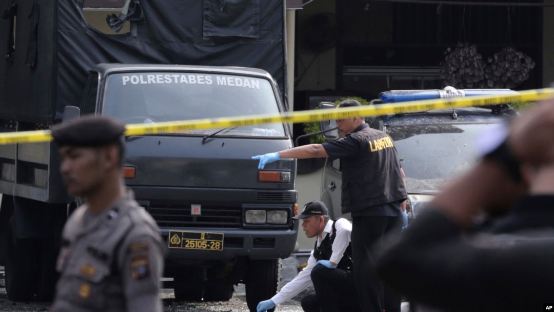 Members of a police forensic team inspect the site of a bombing at the local police headquarters in Medan, North Sumatra, Indonesia, Nov. 13, 2019.
