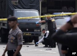 FILE - Members of police forensic team inspect the site of a bombing attack at the local police headquarters in Medan, North Sumatra, Indonesia, Nov. 13, 2019.
