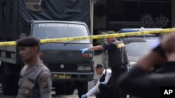 Members of a police forensic team inspect the site of a bombing at the local police headquarters in Medan, North Sumatra, Indonesia, Nov. 13, 2019.