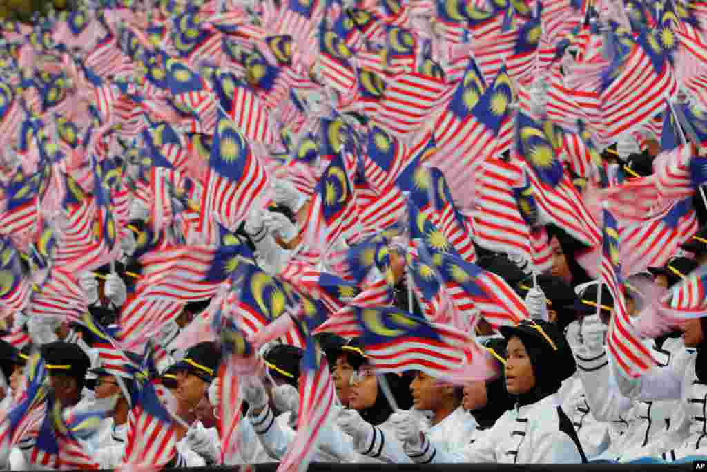 Students wave national flags during 62nd Independence Day celebrations in Putrajaya, Malaysia, Aug. 31, 2019.