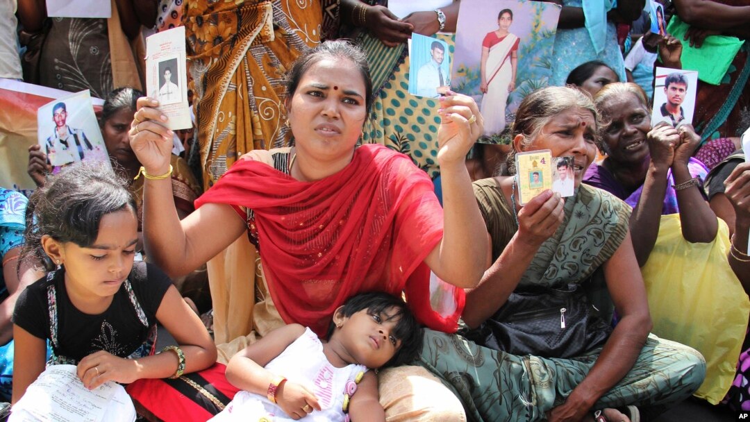 Keluarga warga Tamil memegang foto anggota keluarganya yang hilang, dalam aksi pprotes selama kunjungan Pimpinan Komisi HAM PBB Navi Pillay, di Jaffna, Sri Lanka, 27 Agustus 2013 (Foto: dok). Sri Lanka telah menyatakan16 organisasi Tamil di pengasingan sebagai kelompok terlarang, termasuk Macan Tamil, atas tuduhan terorisme dan melarang warganya untuk mendukung mereka atau melakukan kontak dengan mereka.