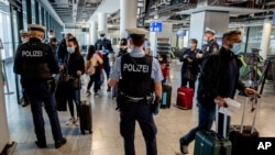 German federal police officers check passengers arriving from Palma de Mallorca for a negative Corona test as they arrive at the airport in Frankfurt, Germany, March 30, 2021.