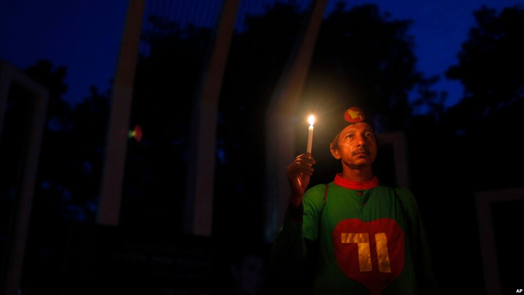 FILE - A Bangladeshi activist holds a candle, as they protest against the killing of secular blogger Niladri Chottopadhay Niloy in Dhaka, Bangladesh, Friday, Aug. 14, 2015.