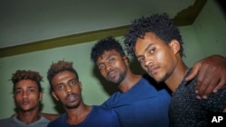 In this photo taken on Thursday, Oct. 10, 2019, from left, Eritrean under-20 soccer players Simon Asmelash Mekonen, Mewael Tesfai Yosief, Hermon Fessehaye Yohannes, and Hanibal Girmay Tekle talk together in a house where they are staying in Uganda.