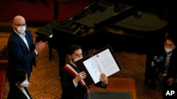 El presidente chileno Gabriel Boric sostiene la versión final de la nueva constitución del país durante una ceremonia en el antiguo Congreso en Santiago, Chile, el lunes 4 de julio de 2022. 