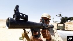 A rebel fighter inspects the condition of a rocket launcher captured from troops loyal to Muammar Gaddafi near the town of Bir al-Ghanam, about 100km (62 miles) south of Tripoli, June 30, 2011.