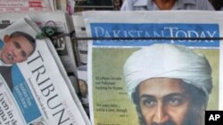 A roadside vendor sells newspapers with headlines about the death of al-Qaeda leader Osama bin Laden, in Lahore May 3, 2011.