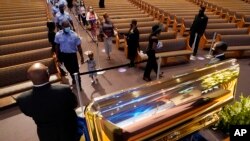 Para pelayat melintas di depan peti jenazah George Floyd yang dibuka untuk umum di Gereja Fountain of Praise, di Houston, Texas, Senin, 8 Juni 2020. (Foto: AP)