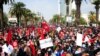 Supporters of the islamist Ennahdha party march with Tunisian flags during a rally in Tunis, Tunisia, Feb. 27, 2021. The party has backed Prime Minister Hichem Mechichi in his standoff with President Kais Saied over a cabinet reshuffle. 