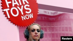 A model dressed as a doll stands in a box during a protest in Zurich, Switzerland, Nov. 15, 2016, by nonprofit organization Solidar Suisse, in support of better conditions for toy factory workers in China.