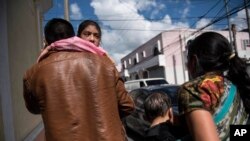 FILE - Seven-year-old Mayra Cristina Gregorio Velasquez is carried by her father after they were reunited at the shelter "Nuestras Raices," following her detention by U.S. immigration authorities in Guatemala City, Aug. 7, 2018.