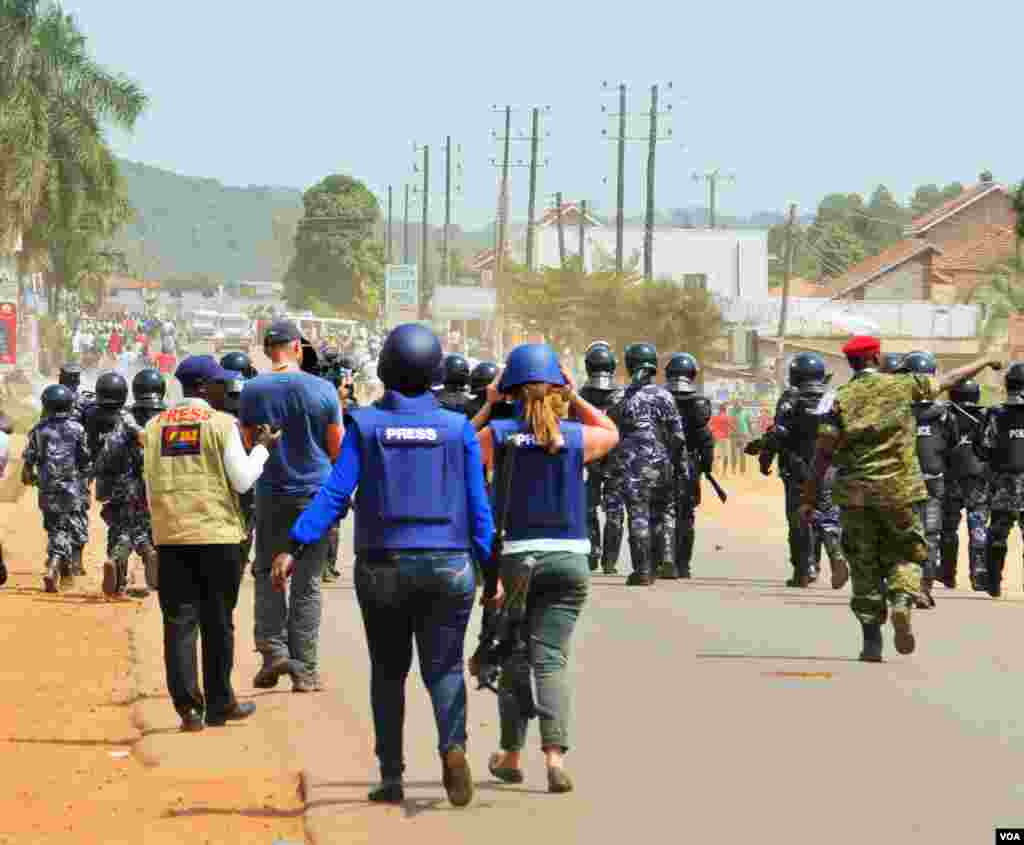 Members of the press stand behind a police line as they advance on protesters, moments before tear gas was fired. E. Paulat/VOA