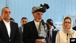 FILE - Afghan President Ashraf Ghani, center, speaks to journalists after voting at Amani high school, near the presidential palace in Kabul, Afghanistan, Sept. 28, 2019.