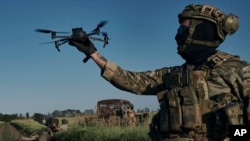 Seorang tentara Ukraina dari brigade ke-28 meluncurkan drone di garis depan dekat Bakhmut, Ukraina, Minggu, 20 Agustus 2023. (AP/Libkos)