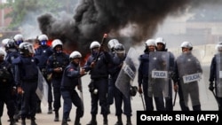 Um polícia prepara-se para atirar gás lacrimogéneo durante manifestação anti-governo, Luanda, 24 outubro 2020