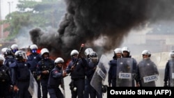 Um polícia prepara-se para atirar gás lacrimogéneo durante uma manifestação anti-gGoverno, Luanda 24 outubro 20