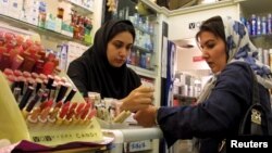 FILE - An Iranian woman tests the colours of make-up at an upscale shop in north Tehran. 