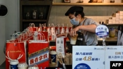 FILE - A Luckin Coffee employee prepares baijiu liquor-flavored latte, the latest product in collaboration with Chinese liquor brand Kweichow Moutai, at a Luckin Coffee shop in Beijing on Sept. 4, 2023.