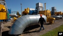 A gas pipeline station worker passing the gas pressure engines in Bil 'che-Volicko-Ugerske underground gas storage facilities in Strij, outside Lviv, Ukraine, May 21, 2014. 